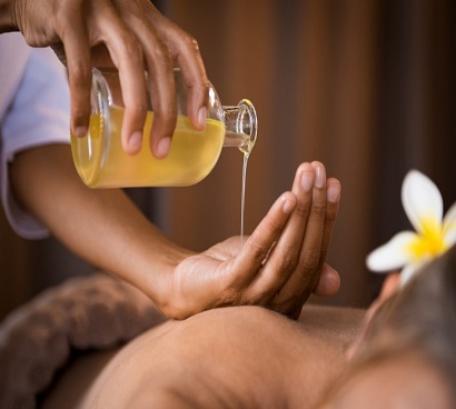 massasge therapist is pouring oil on her hand in massage center DHA Karachi